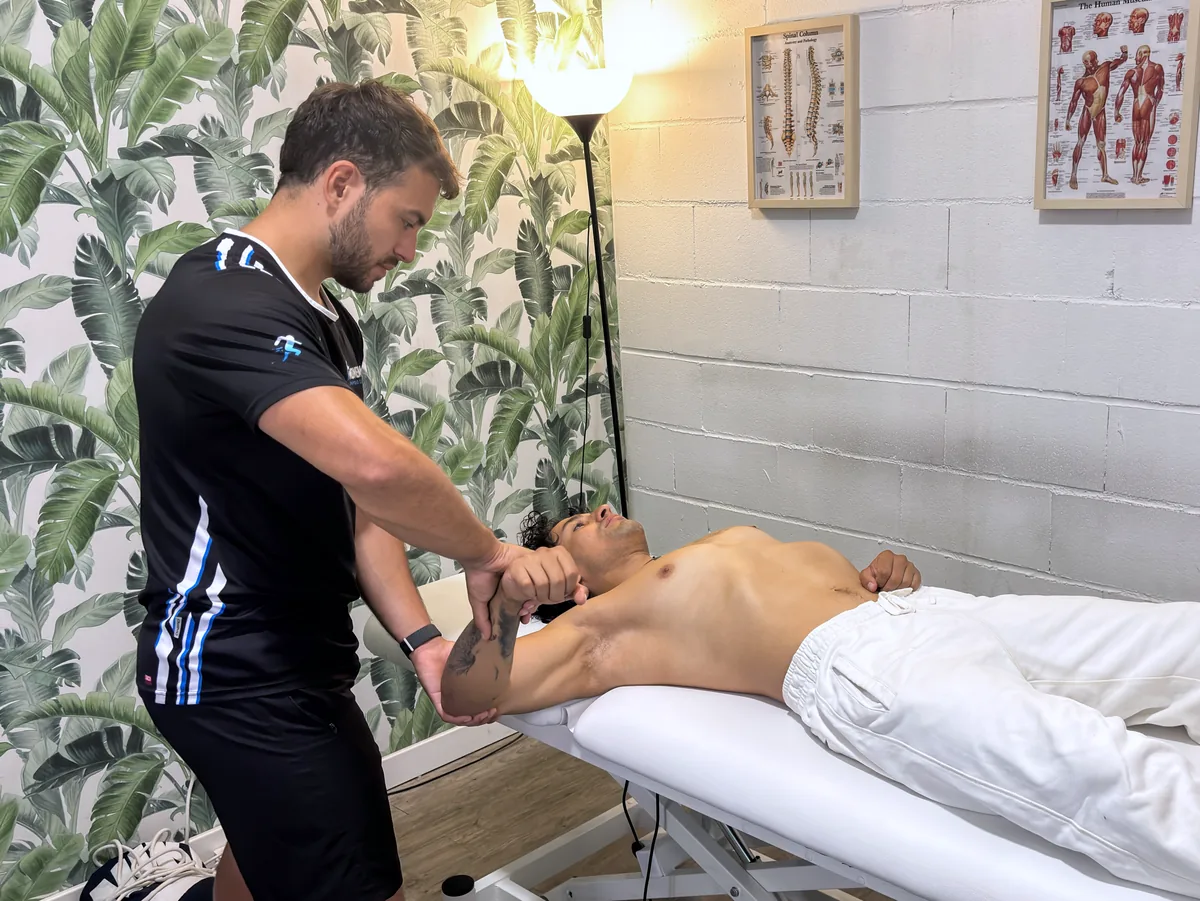 Fisioterapeuta deportivo tratando el hombro de un deportista en Momentum, Colmenar Viejo