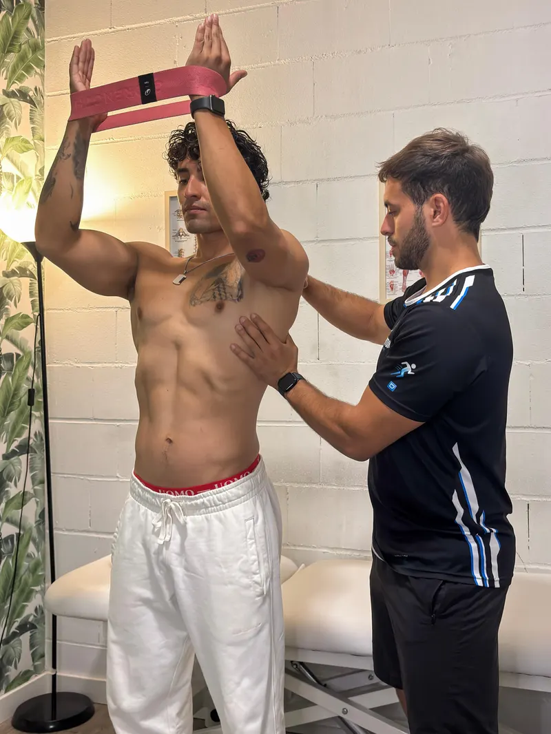 Alex guiando un ejercicio de hombro con banda elástica en su consulta de Colmenar Viejo